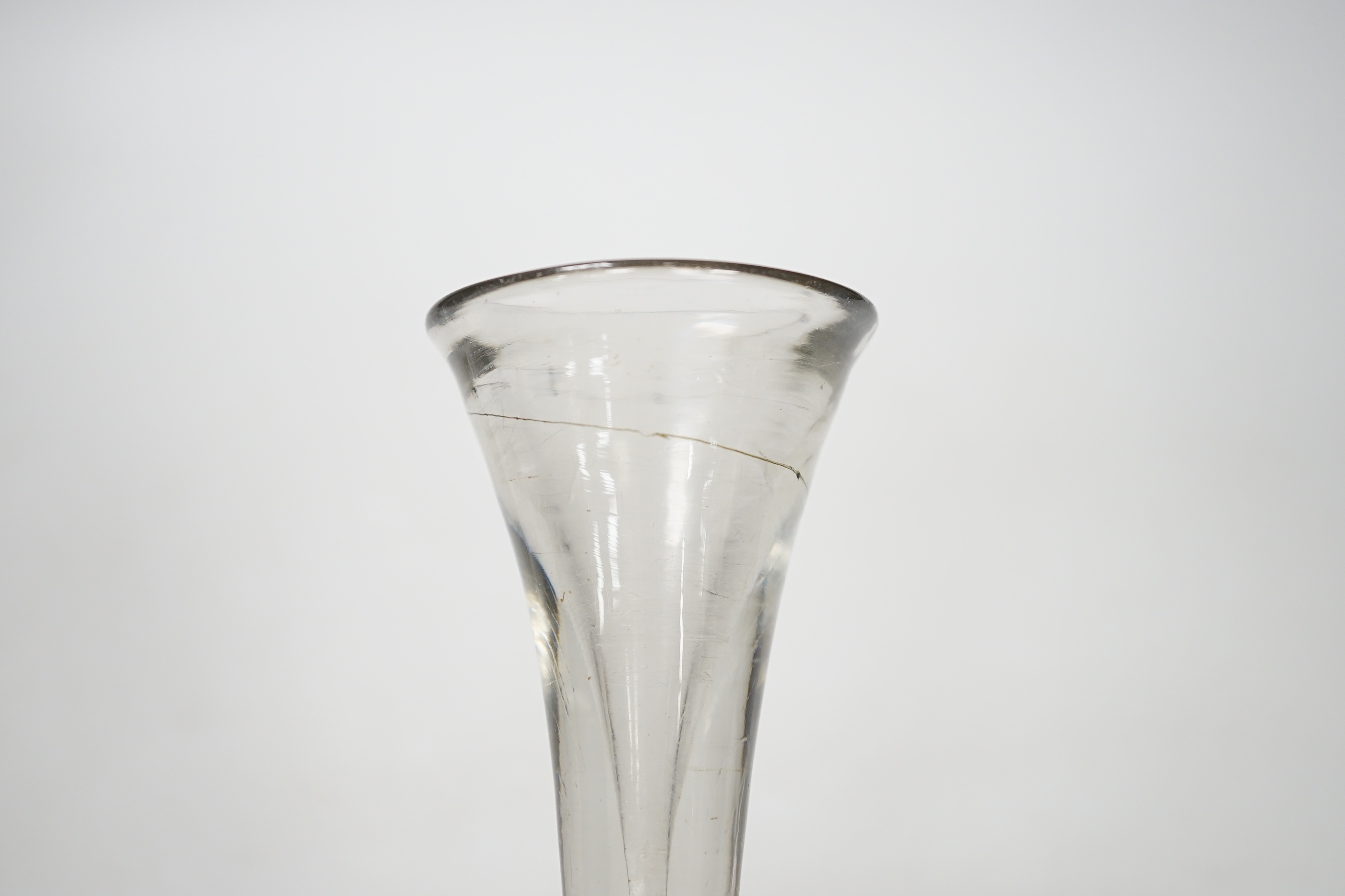 An English lead crystal baluster toastmaster’s glass, c.1710-20, elongated trumpet deceptive bowl on triple flattened annular knop, plain teared section includes a basal knop, conical folded foot, 15cm high